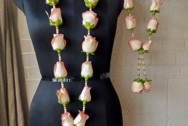 Blush pink and white rose varmala with pearl and golden bead accents for a romantic wedding.